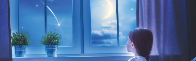 Girl looking out window at the moon